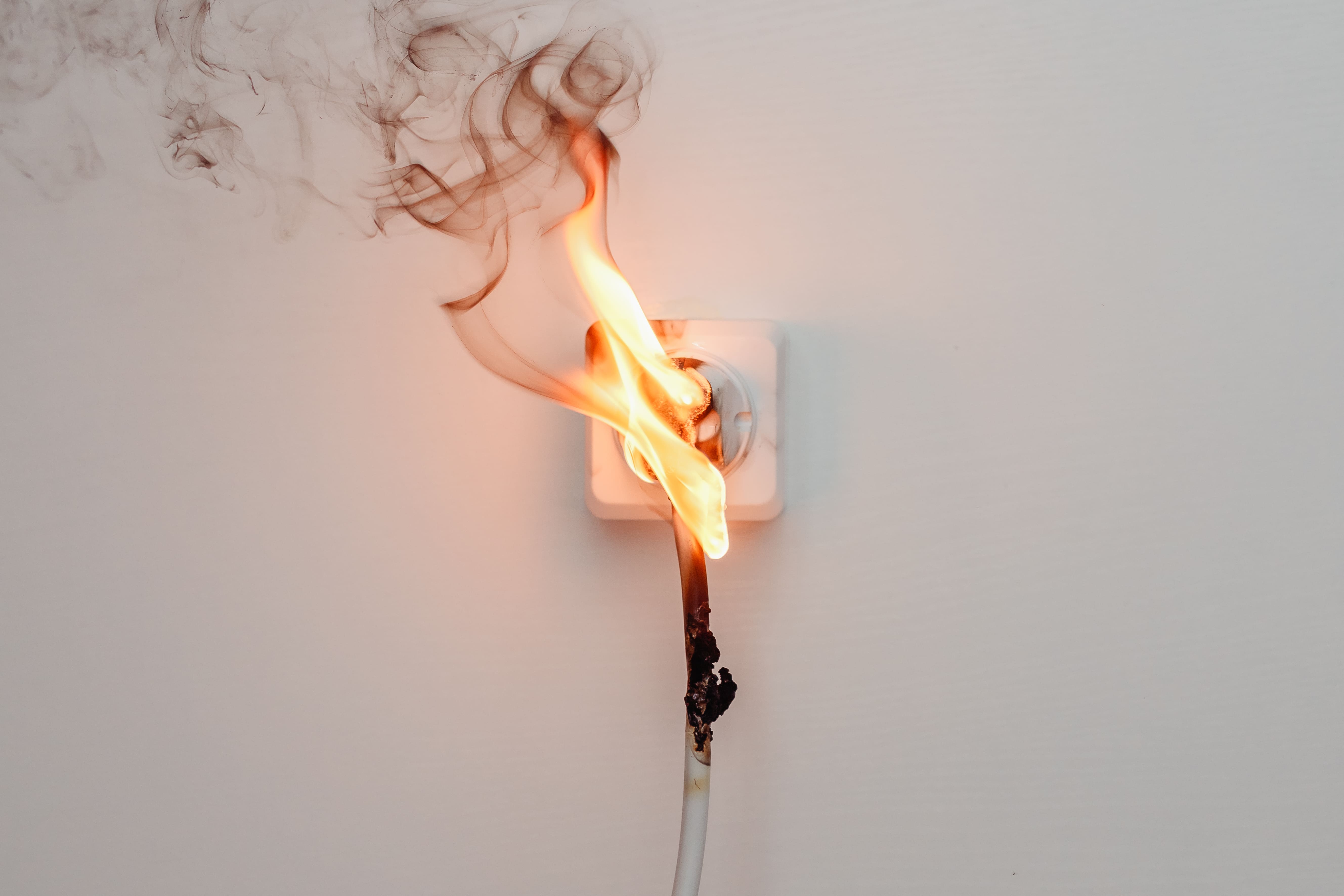 Defekte oder überlastete Steckdose als Symbol für Risiken ungeprüfter elektrischer Betriebsmittel